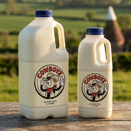 COWBOYZ A2 raw milk 2 litre and 1 litre jugs on a rustic oak table in the Kent countryside