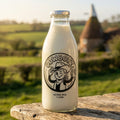 COWBOYZ A2 raw milk glass bottle on a rustic oak table in the Kent countryside